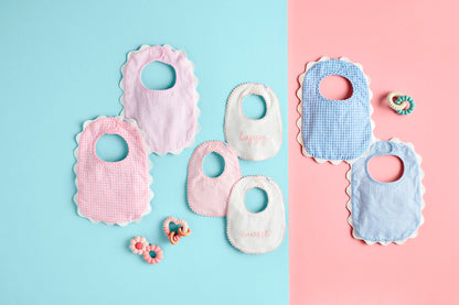 Six pastel seersucker and gingham scallop trim bibs. Available in one size suitable for infants.