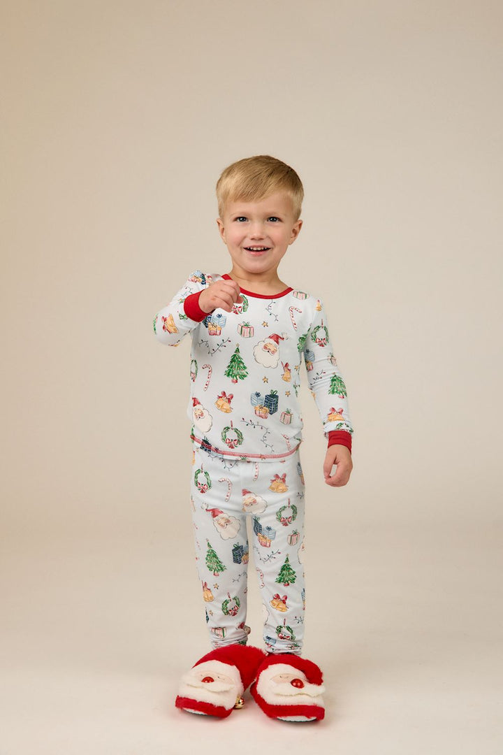 Light blue long-sleeve bamboo Christmas print PJs featuring Santa, trees, and gifts with red cuffs. Available in little kids sizes.