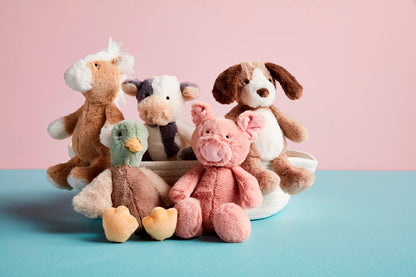 The Farm Plush Rattle Pals are soft plush rattles featuring a horse, cow, dog, duck, and pig with faux fur coats. Each sits in a decorative white basket. Sizes available were not specified.