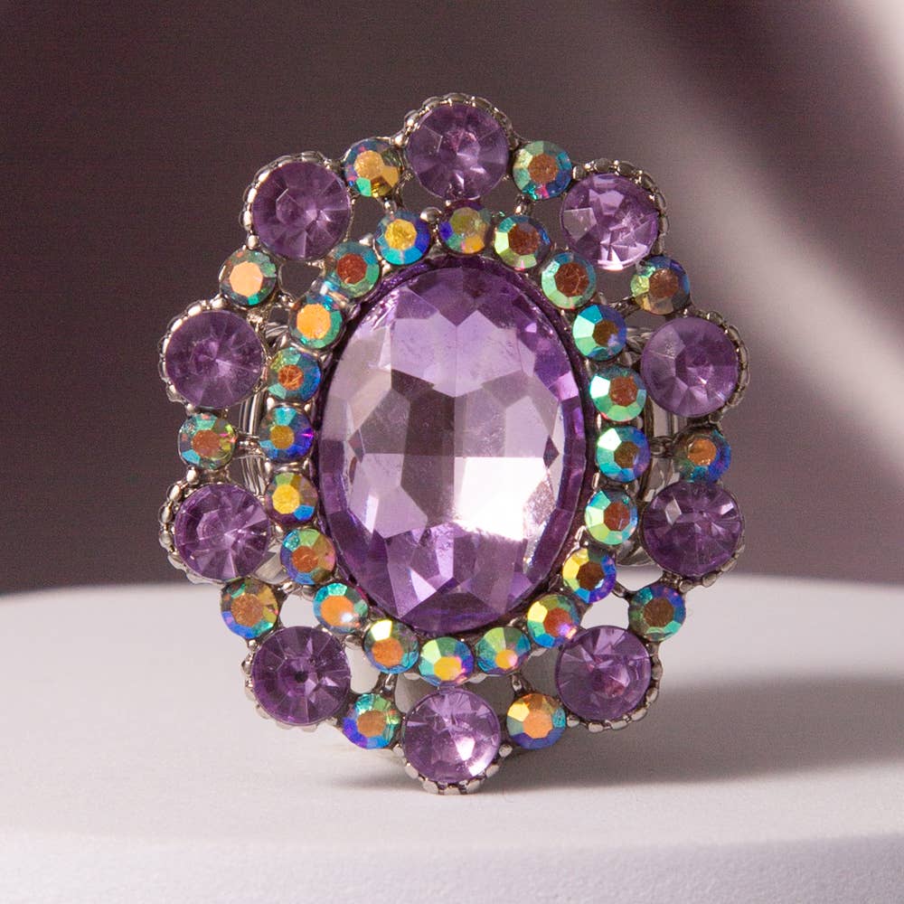 Oval Crystal Sunburst Double Halo Stretch Ring with large purple gem, smaller purple stones, iridescent accents. Sizes: stretch fit.