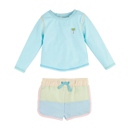 The Seersucker Rash Guard & Swim Trunks Set includes: - Light blue rash guard with palm tree design - Striped swim trunks in pastel yellow, green, and blue - Tie waistband Available Sizes: 2T, 3T, 4T, 5T.