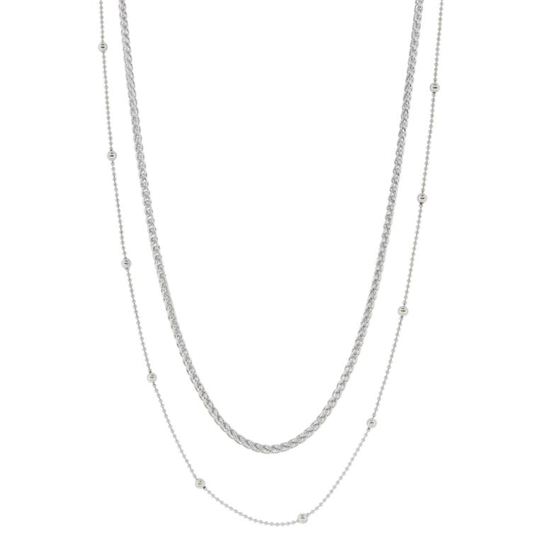 18K white gold-plated minimalist wheat and satellite chain necklace with layered design. Features two thin chains measuring 16 and 18 inches, adorned with small metal beads. Elegant and sophisticated touch.