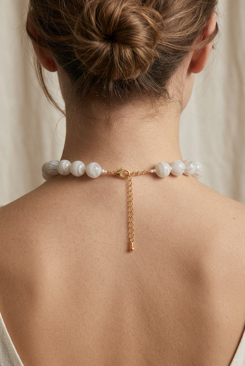 Marbled beaded necklace with round white-and-grey beads, gold-tone clasp, and extender chain. Available in all sizes.