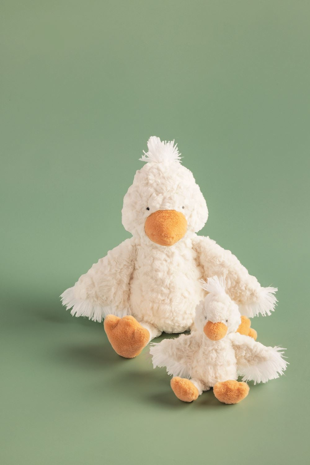 Two faux fur duck toys with white bodies, orange beaks and feet. Available in two sizes: Mama (large) and Baby (small).