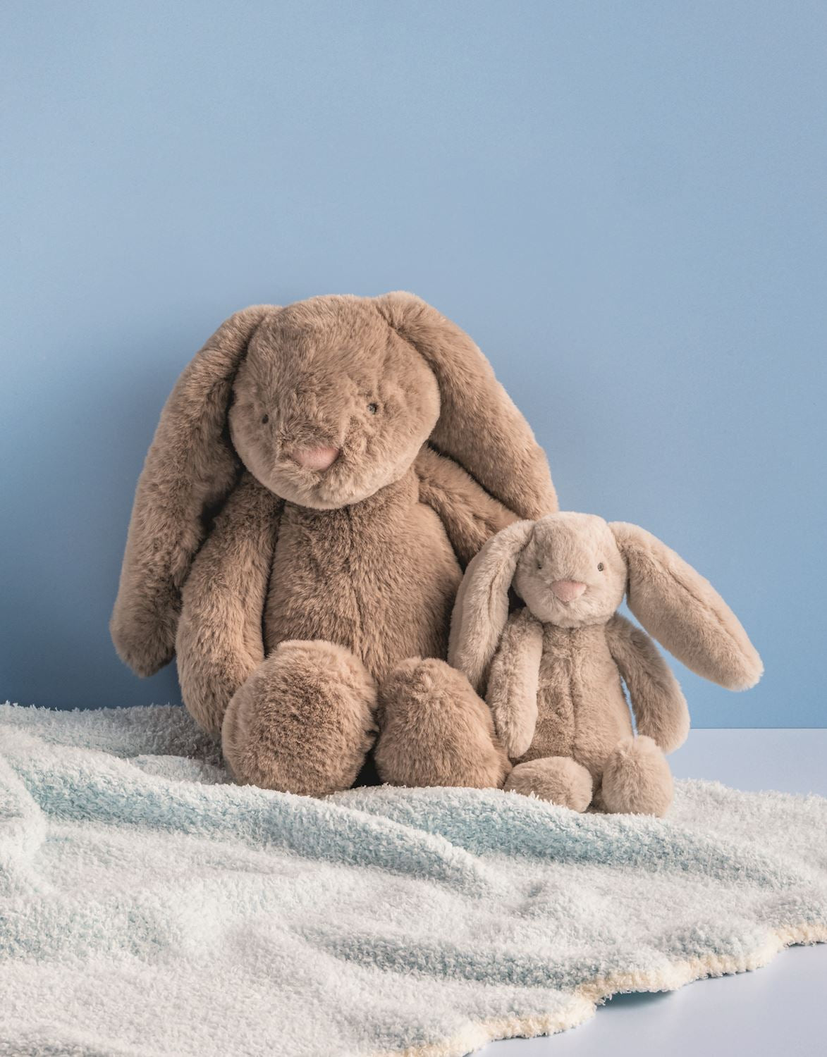 The Mama & Baby Plush Set includes one large brown and one small beige faux fur bunny. Available in large and small sizes.