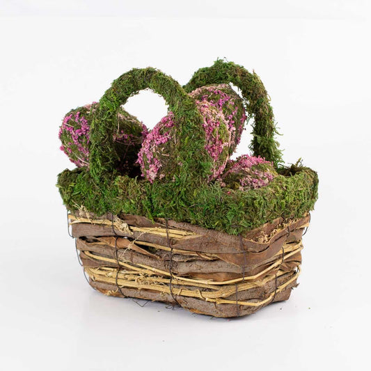 The Dorothy Moss Basket features intertwined moss handles, pink-speckled heart shapes, in green and natural tones on a white background. Sizes available: Small, Medium, Large.
