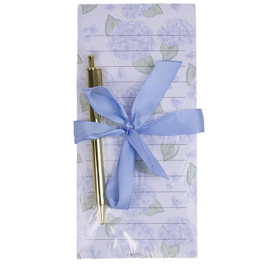 Hydrangea Notepad Gift Set: Lined notepad with light purple flowers and green leaves, tied with a light blue ribbon; includes a gold pen. Sizes available: Not specified.