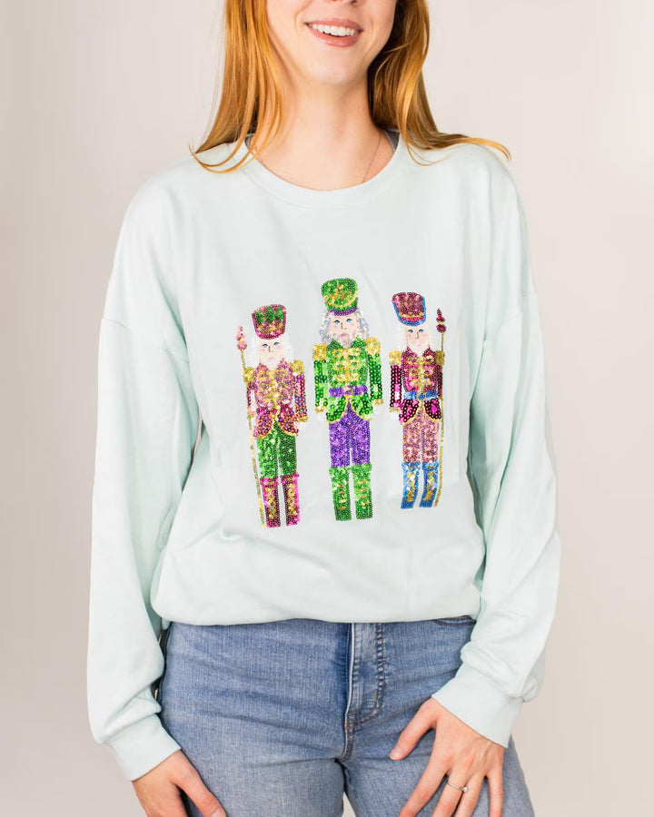 Mint green Candy Nutcracker sequin sweatshirt featuring three sequined nutcracker figures.
