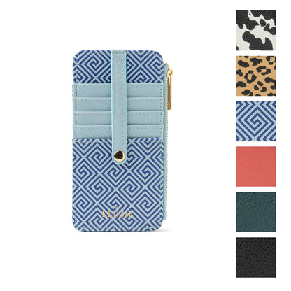 The Kedzie Essentials Only Zippered Wallet in “Greek to Me” is a compact blue patterned vegan leather wallet with card slots, a central strap, and a zippered pocket for cash. Available sizes are not specified.