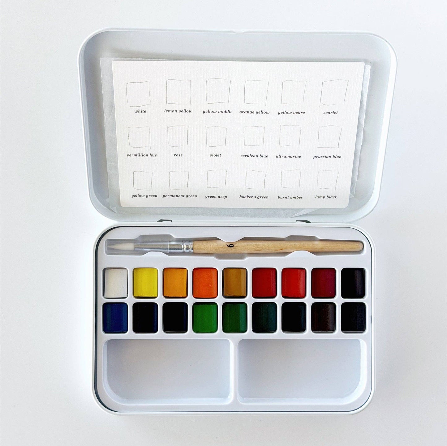 Compact watercolor set with 18 pans, a wooden-handled brush, paint swatch card, all in a white tin box. Available in travel size.