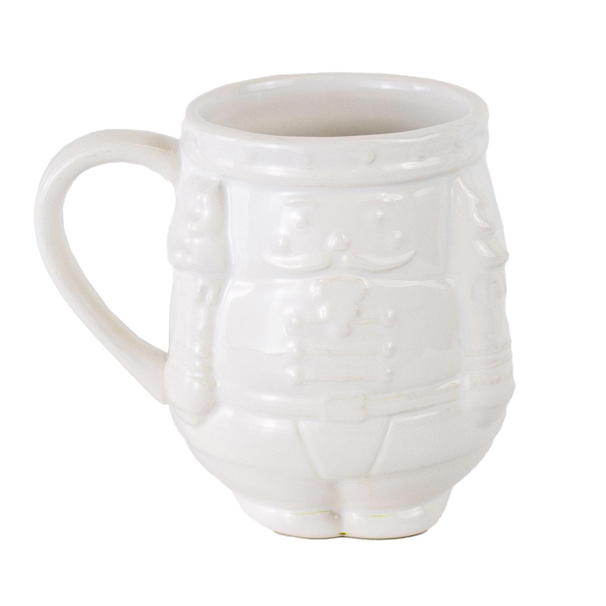 White ceramic nutcracker-shaped mug with a textured design, featuring a smile, scarf, and buttons. Sizes available: 12 oz and 16 oz.