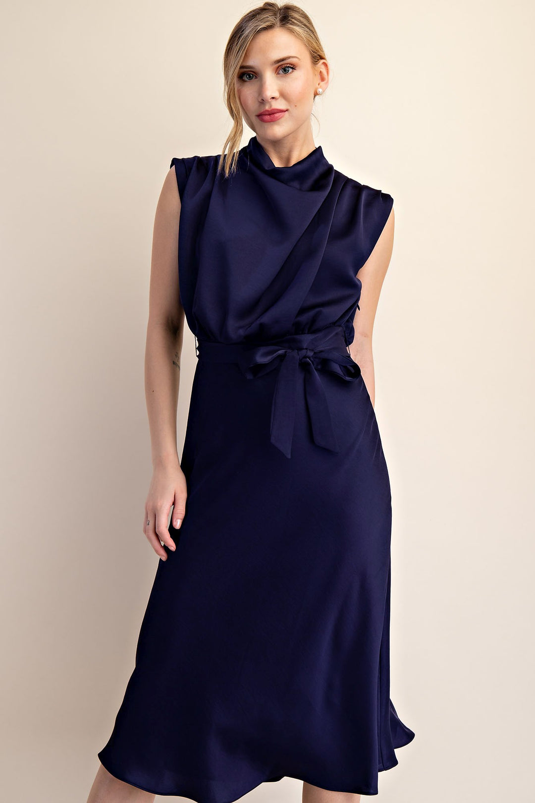Sleeveless dark navy midi dress with a draped cowl neck and tied waist. Available in XS–XL.