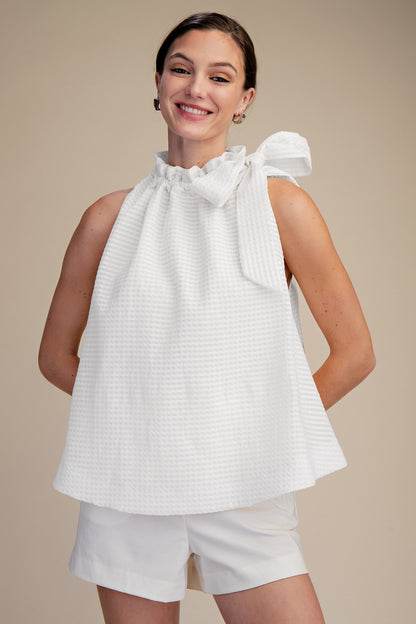 White Ruffle Neck Tie Sleeveless Top, available in sizes XS-XL. Features ruffled neckline and sleeveless design.