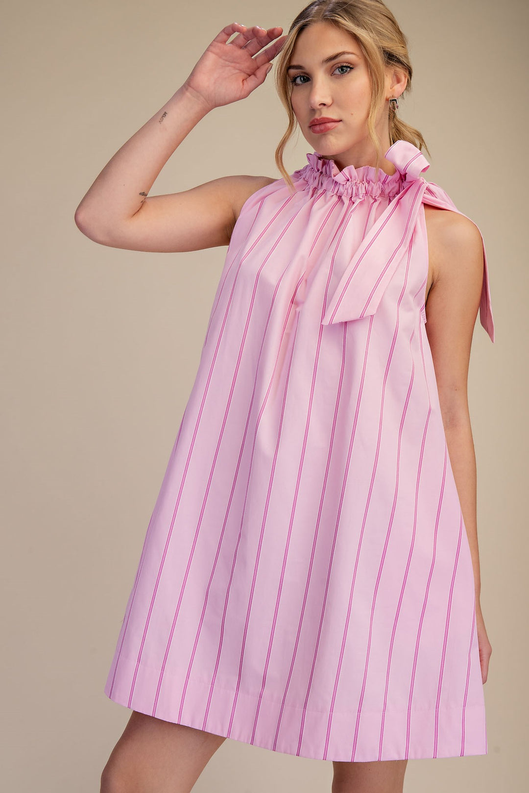 Pinstripe Pink Tie-Neck Sleeveless Dress with ruffled high neck, shoulder bow, loose fit. Available in sizes XS-XL.