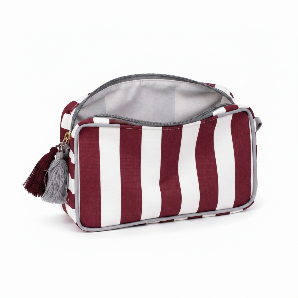 Maroon and white striped laminated canvas cosmetic bag with gray trim, tassel, light gray interior. Sizes: small, large.