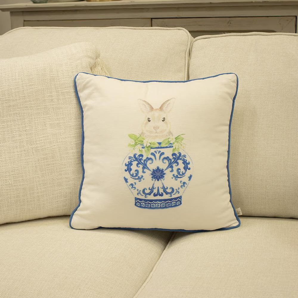 The Winston Reversible Bunny Pillow displays a rabbit in a blue ornate vase with green leaves, bordered by white and blue. Available sizes: 18x18 inches, 20x20 inches.