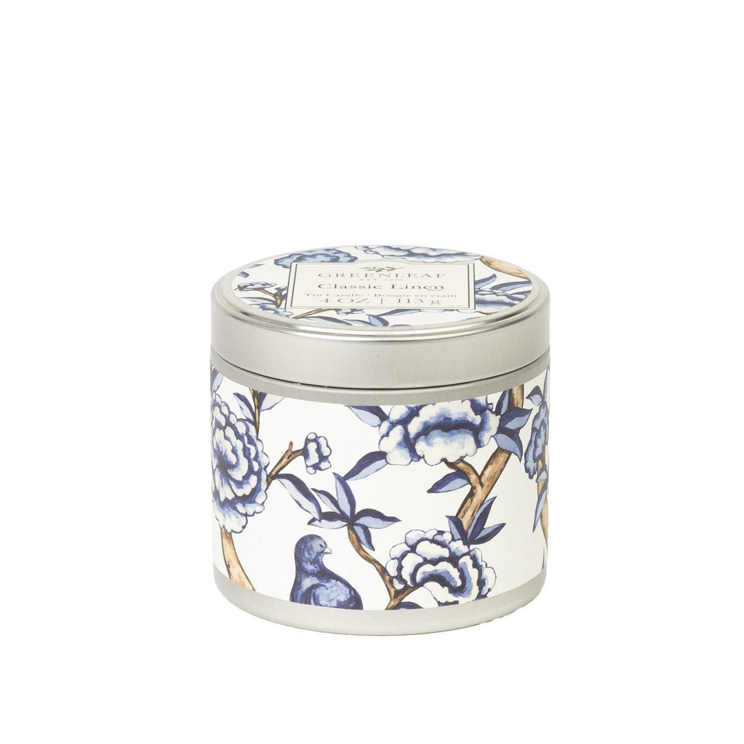 Classic Linen Tin Candle: round, light gray lid, blue/white floral design, "Crisp Linen" label. Available in travel size.