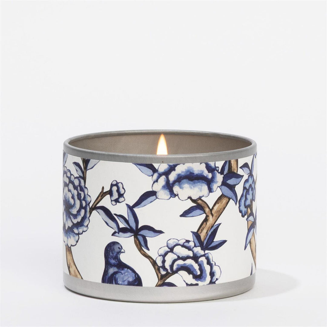 Lit Classic Linen Tin Candle with blue and white floral patterns, bird design. Available sizes: small, medium, large.