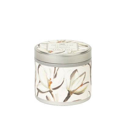 Magnolia Tin Candle: round tin, silver lid, white-green floral design, "Chesapeake Bay" label. Available in 6oz and 12oz sizes.