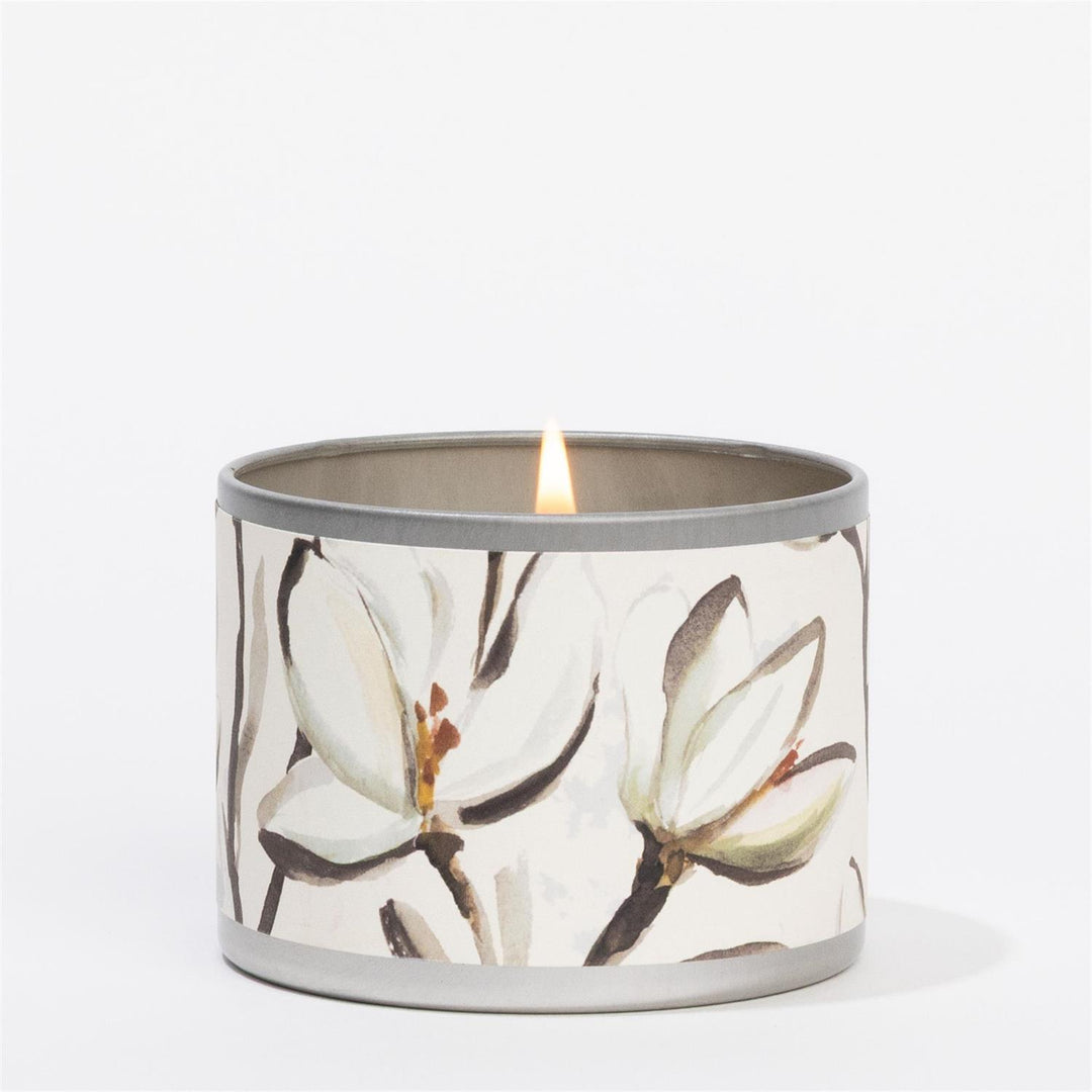 Magnolia Tin Candle: travel size, round tin, floral design with white magnolias and brown branches. Sizes available.