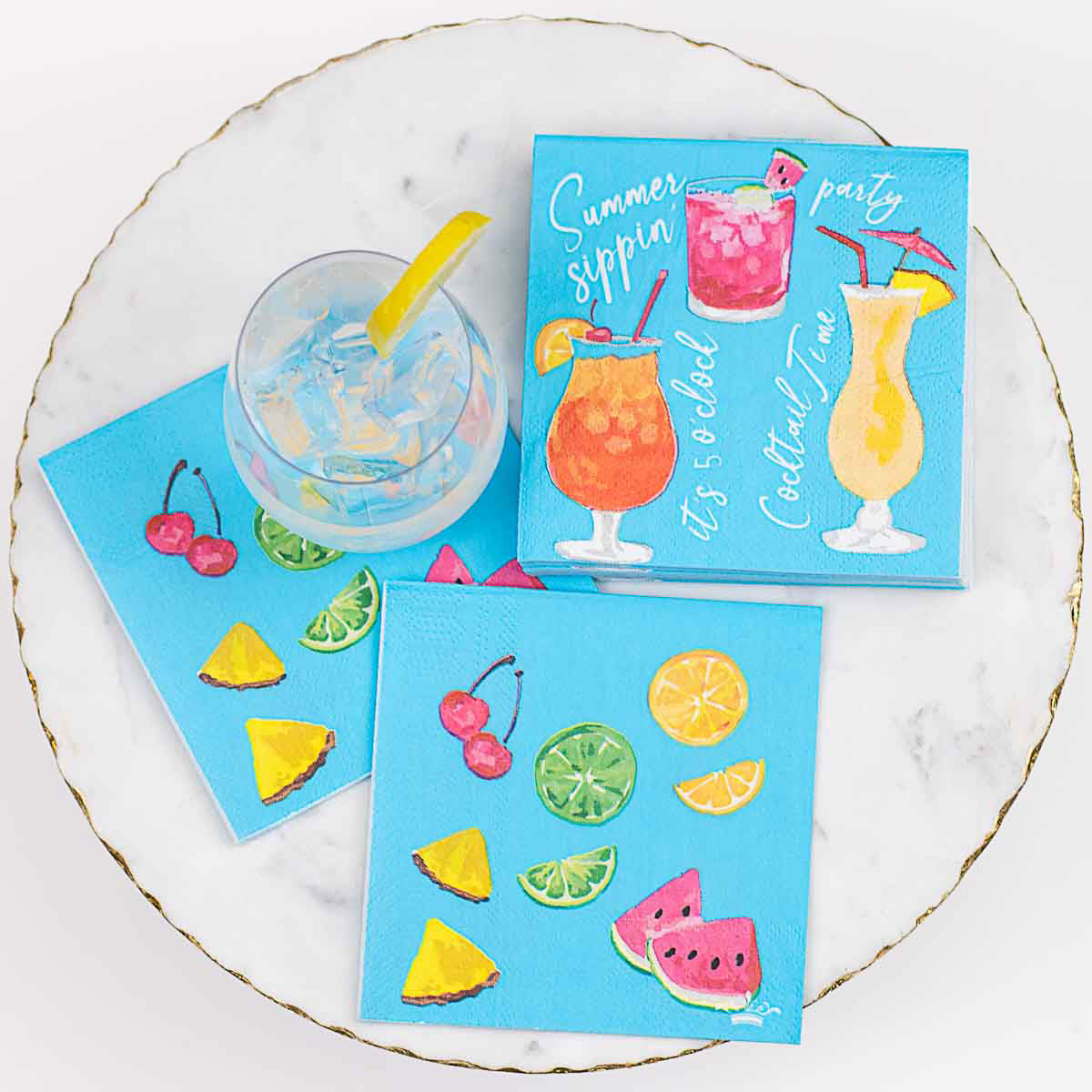 The product is the Mango Tango 5 O'Clock Cocktail Napkins. These are vibrant, colorful napkins with detailed illustrations of various fruity beverages. They're perfect for summer gatherings or tropical-themed parties.