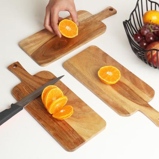 Acacia Wood Cutting and Serving Boards (Set of 3, small/medium/large) shown in use with fruit and knife on boards.