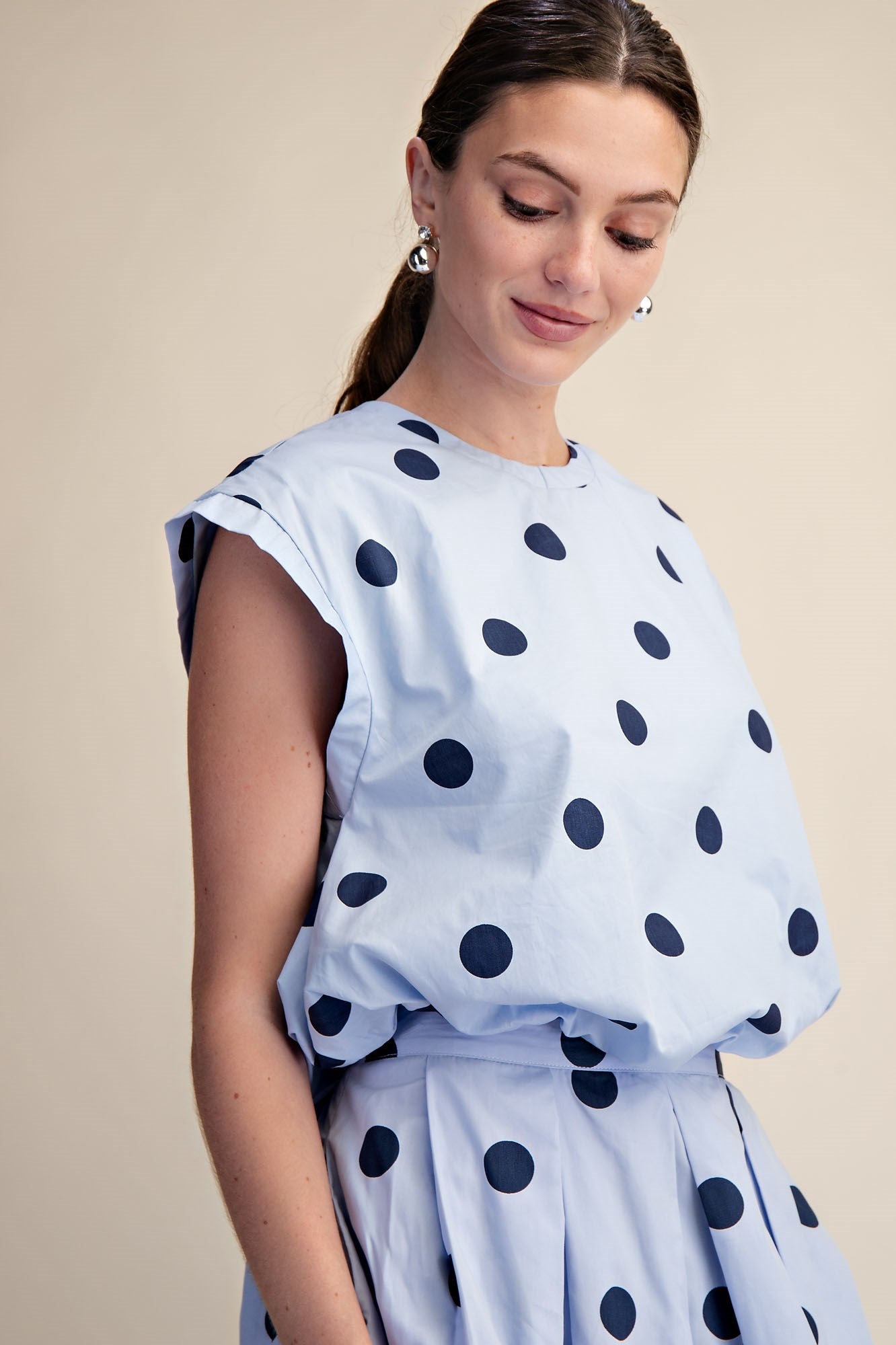 Blue Polka Dot Bubble Top with pleated design, available in sizes XS-XL.