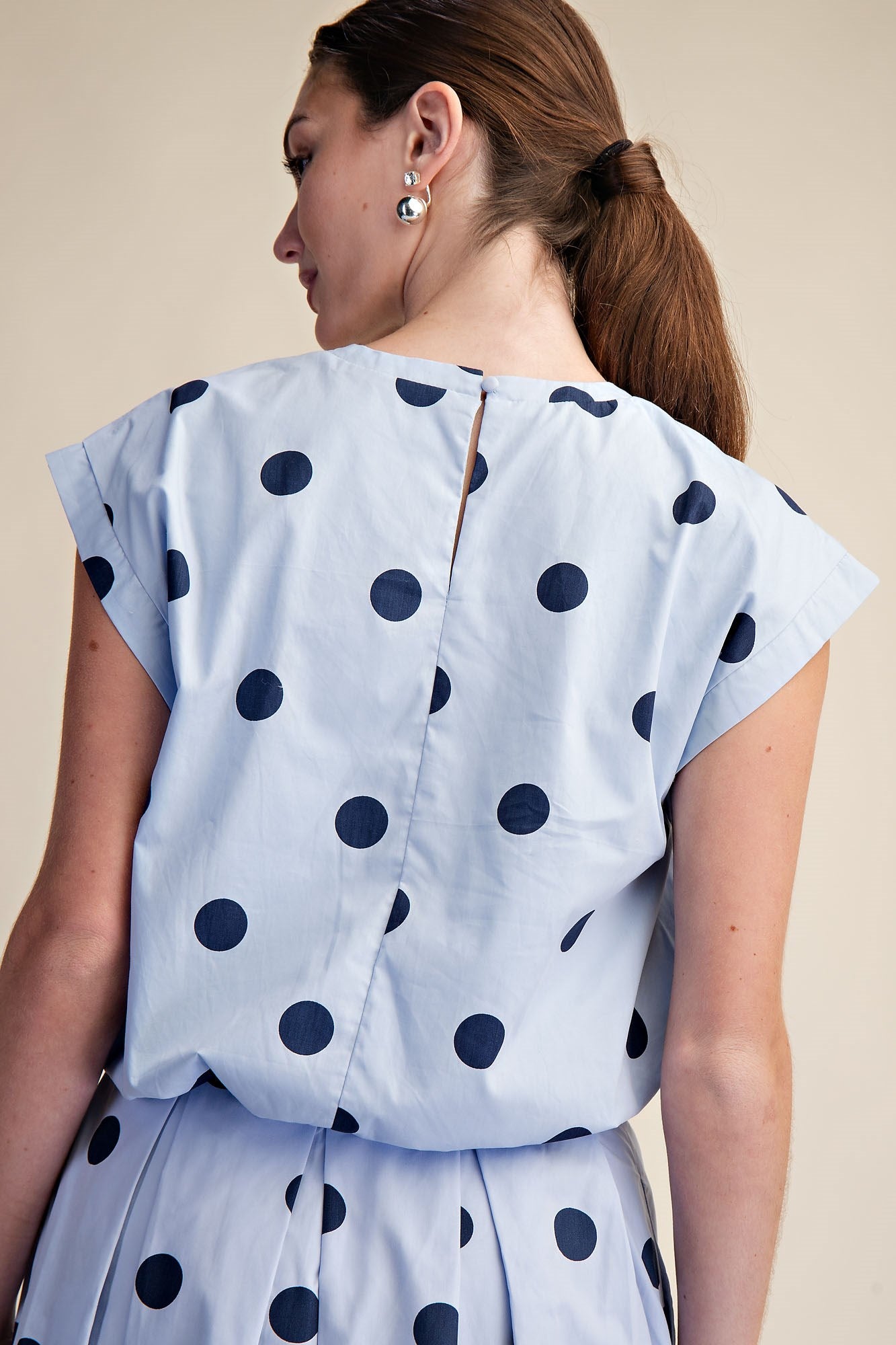 Blue Polka Dot Bubble Top with short sleeves, shown from the back. Available in sizes XS–XL.