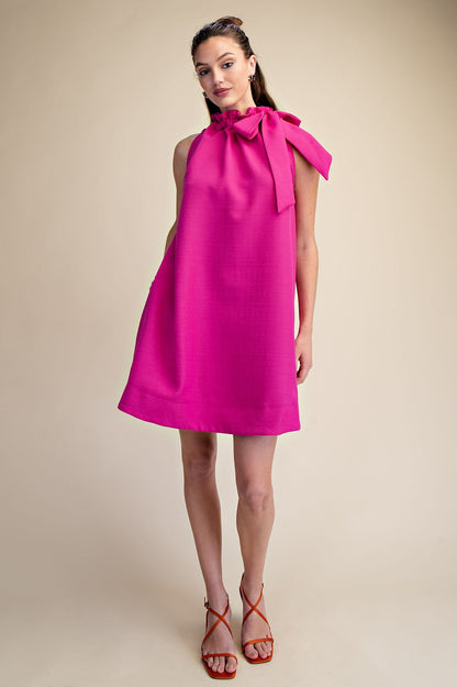 Magenta Tie-Neck Sleeveless Dress with bold bow detail; available in sizes XS-XL.