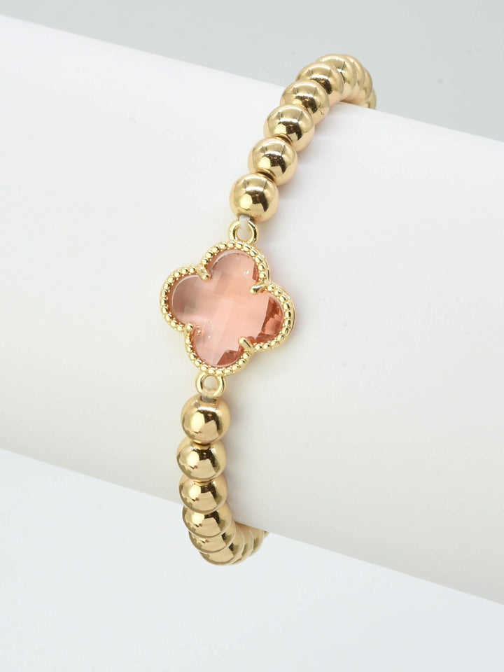 Gold beaded bracelet with pink crystal clover charm at center. Available in S, M, and L sizes.
