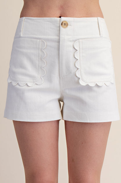 High-waisted white shorts with scalloped pockets, button closure. Available in sizes XS-XL.