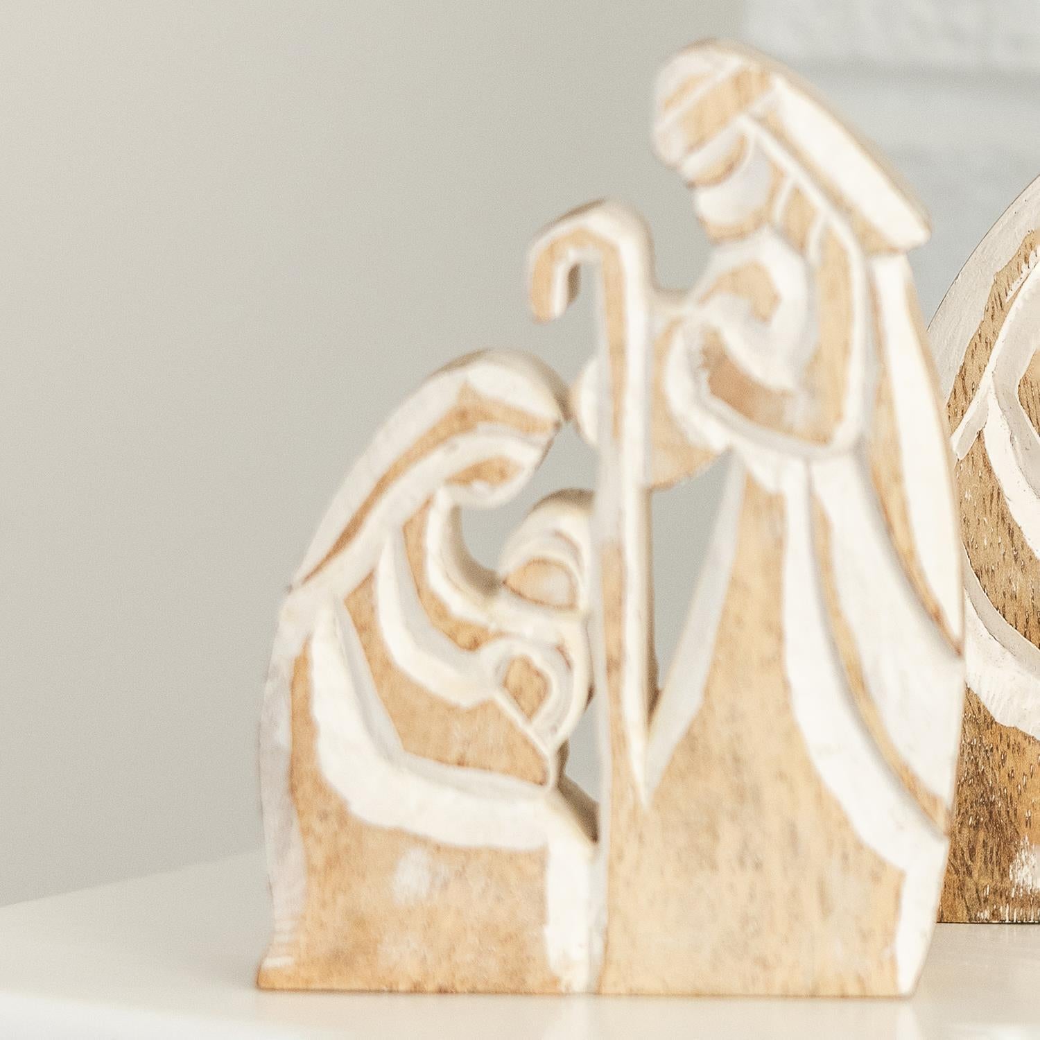 The Wood Rustic Nativity features a stylized depiction of Mary, Joseph, and baby Jesus in light wood. Available size: 10 inches tall.