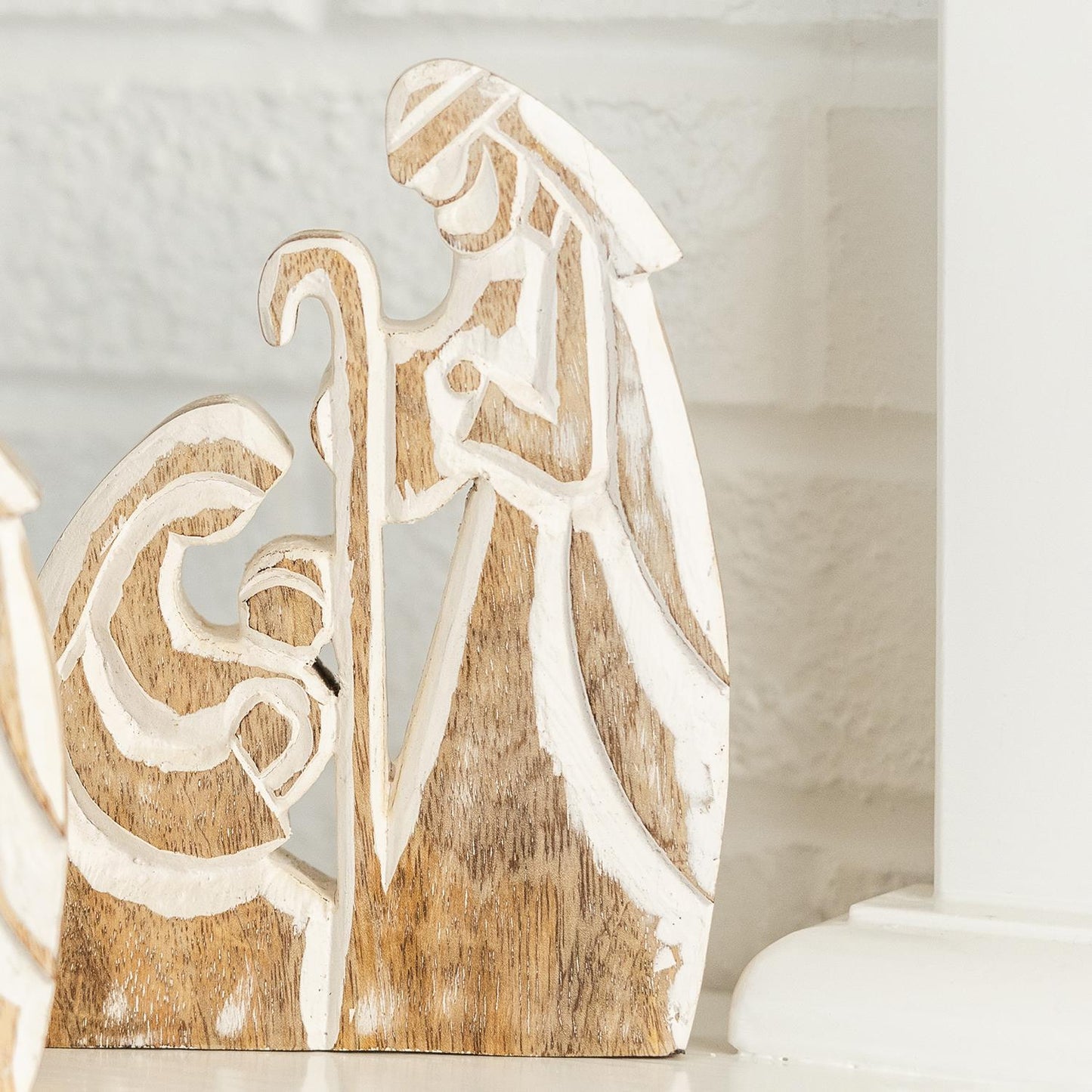 The Wood Rustic Nativity features two abstract figures and a shepherd's staff against a light background, embodying the Christmas spirit. Sizes available: Small, Medium, Large.