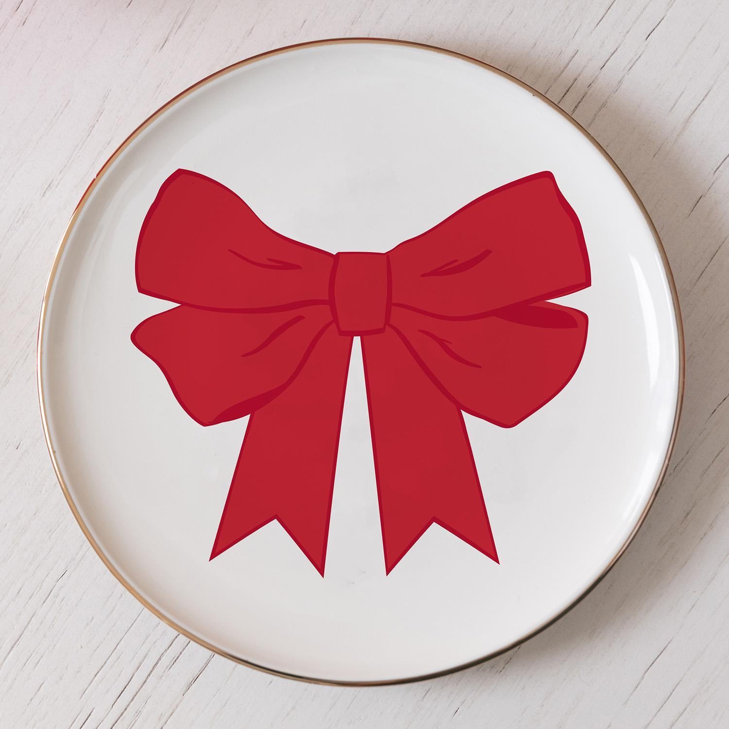 Appetizer Red Bow Plate: Festive serving dish with a bold red bow, ribbon tails, and a gold-colored rim. Available in 10-inch diameter size.