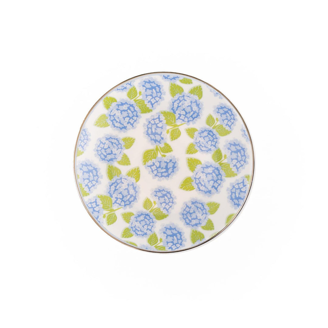 The Hydrangea Appetizer Plate is round, white with a blue hydrangea and green leaves floral pattern. Available in 8-inch diameter.