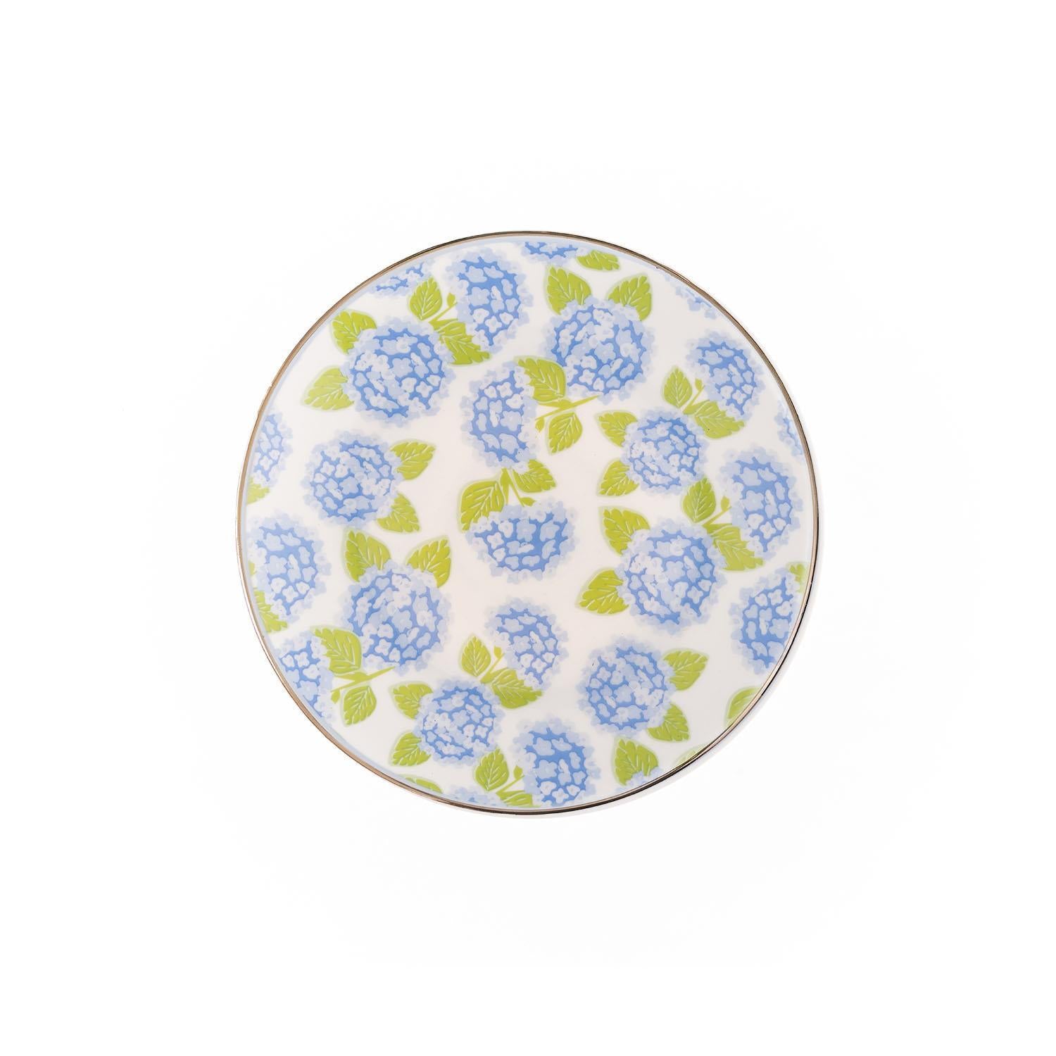 The Hydrangea Appetizer Plate is round, white with a blue hydrangea and green leaves floral pattern. Available in 8-inch diameter.