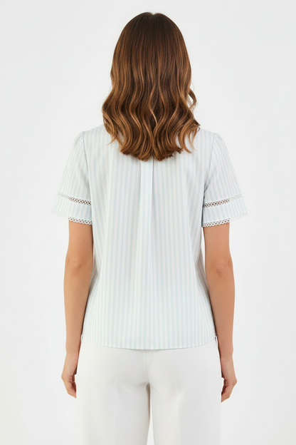 Tabby Pin Stripe Blue Top: light-colored, short-sleeve blouse with decorative lace trim. Available in sizes XS–XL.