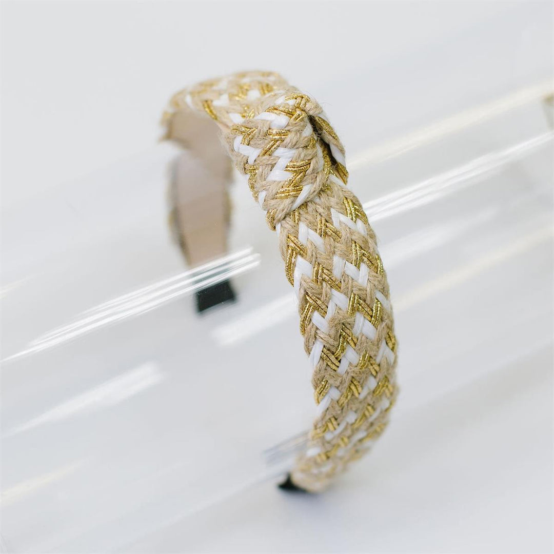 The Chloe Headband features intertwined white and gold threads in a zigzag pattern. Available sizes: One size fits most.