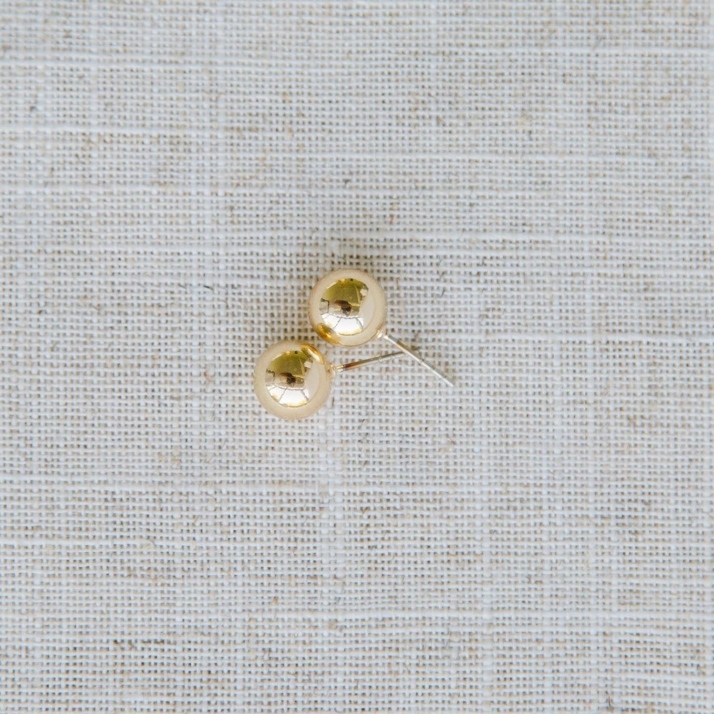 Grenada Earrings: Small, round gold stud earrings with hypoallergenic surgical steel posts. Available in one size.
