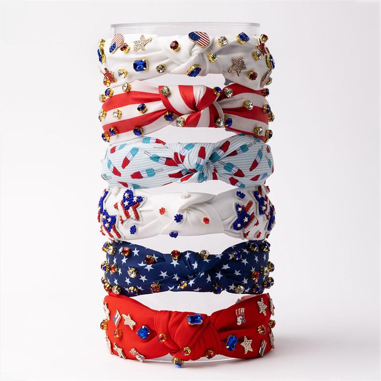 The product is a stack of Americana Headbands, adorned with stars, stripes, and various patriotic charms such as flags and national symbols. They come in standard size to fit most people.