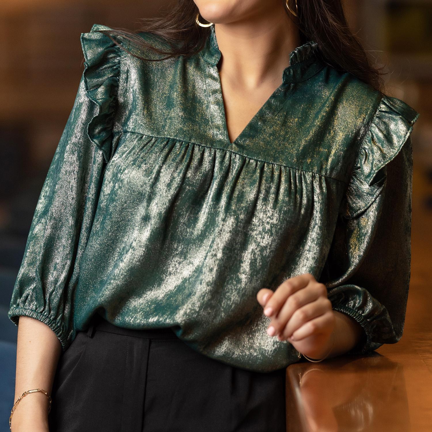 The Parker Top features shimmery fabric and ruffled sleeves. Available sizes: XS, S, M, L, XL.