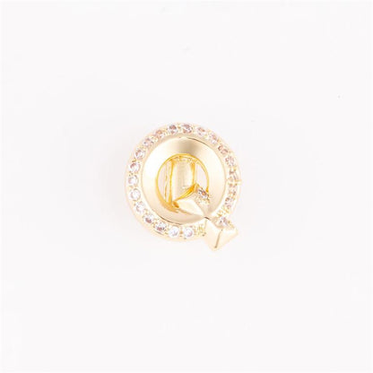 Gold circular pin with gemstone border and stylized "Q" design. Available in small, medium, and large sizes.
