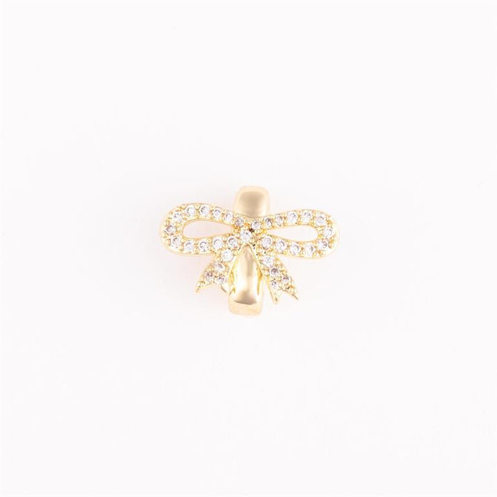 Gold bow-shaped bracelet charm with clear stones. Elegant, timeless design. Available sizes: S, M, L.