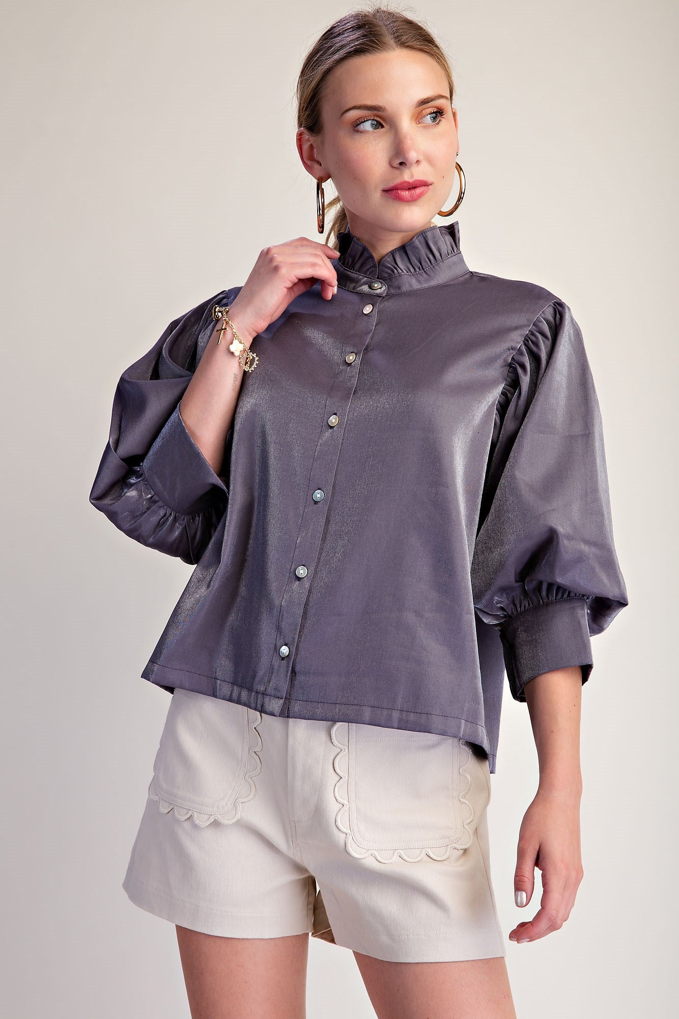Silver Starlight Blouse: shiny, metallic-effect purple button-up with puffed sleeves and subtle ruffle neckline. Available in sizes XS–XL.