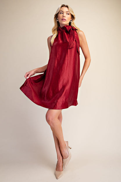 Camille Metallic Tie-Neck Dress: sleeveless, shiny red metallic fabric, statement tie-neck with large bow. Available in sizes XS-XL.