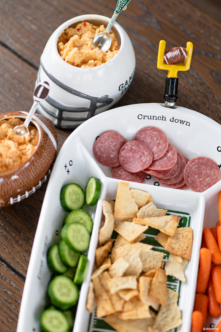 Football-themed snack tray with playful football designs and Game Day Dip Bowl, both featuring festive decorations; available in small, medium, and large sizes.