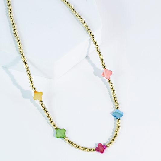 The Petal Pop Necklace by Treasure Jewels with gold and pastel flower beads in yellow, green, blue, pink, and red. Sizes available.