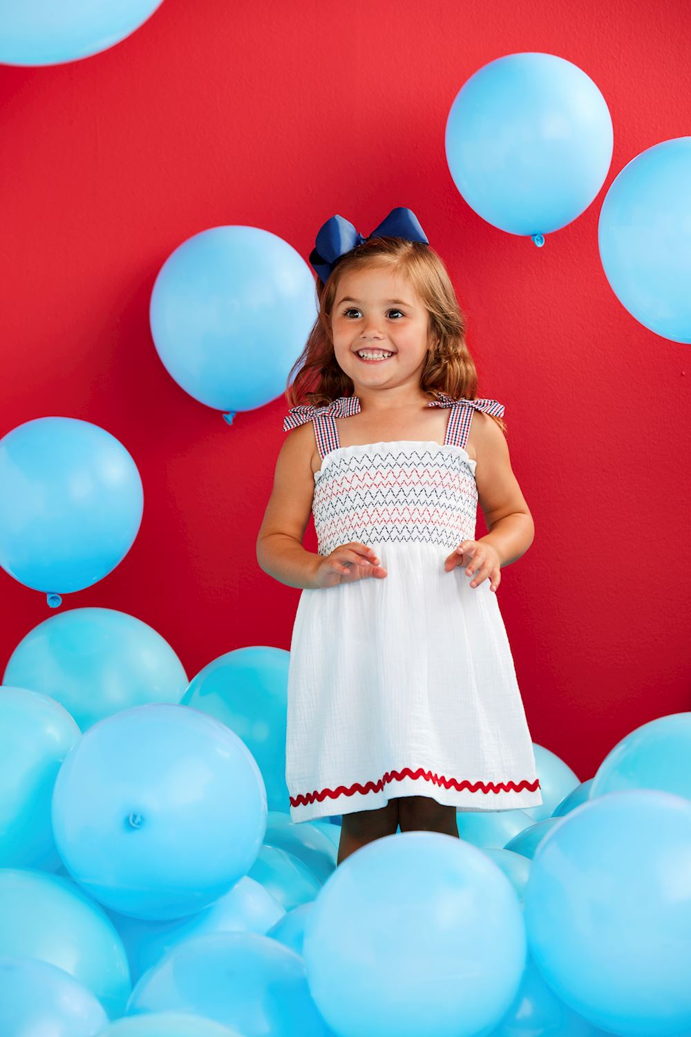White Smocked Gauze Toddler Dress featuring red and blue details. Sizes available: 2T, 3T, 4T, 5T.