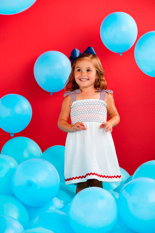 White Smocked Gauze Toddler Dress featuring red and blue details. Sizes available: 2T, 3T, 4T, 5T.