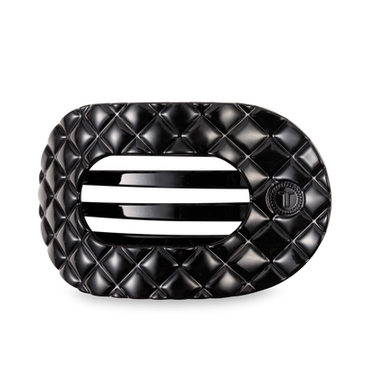 Black oval TELETIES Flat Round Hair Clip with quilted pattern, slats, "T" emblem; available in large and small sizes.